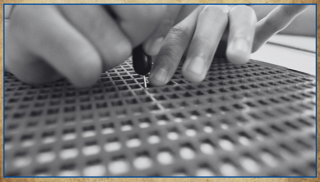 ब्रेल लिपीमा केही लेख्दै एक ब्यक्ति । तस्विर क्लोजअपमा छ । लेखकको हात र ब्रेल लिपी मात्र देखाइएको छ । 