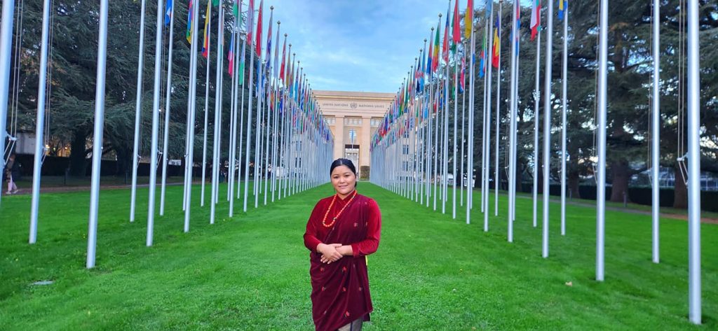 राष्ट्रिय बहिरा महासङ्घ नेपाल, गण्डकी प्रदेश, अध्यक्ष  सुनिता थापा अन्तराष्ट्रिय सम्मेलनमा सहभागिहुने क्रममा मगर पोशाकमा खिचिएको तस्विर । तस्विरको पछाडी सहभागी राष्ट्रको झण्डाहरु रहेको छ । 